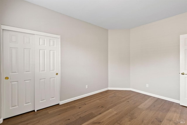 unfurnished bedroom featuring wood-type flooring and a closet