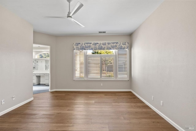 spare room with hardwood / wood-style floors and ceiling fan