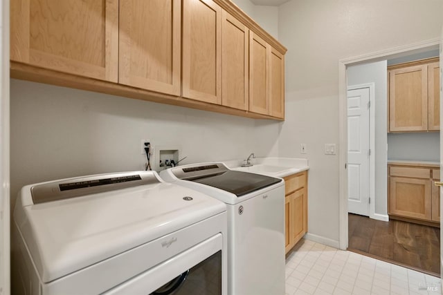 clothes washing area with cabinets, separate washer and dryer, and sink