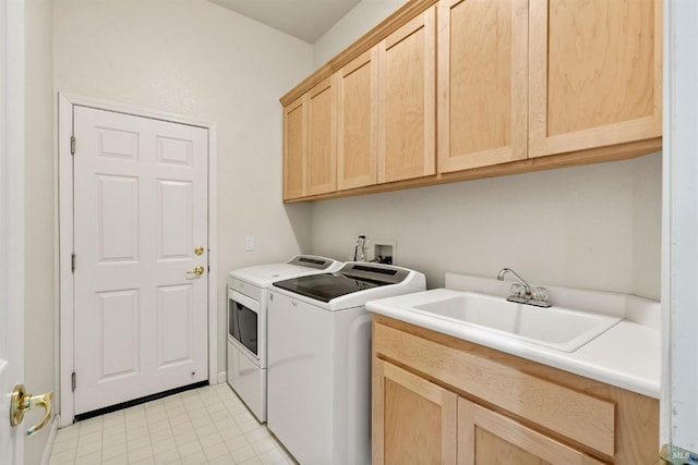 laundry room featuring separate washer and dryer, sink, and cabinets