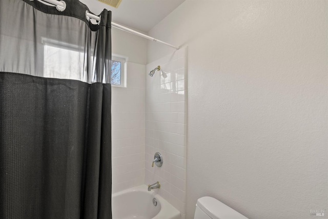 bathroom with toilet and shower / bath combo