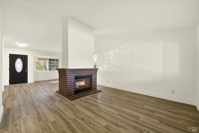 unfurnished living room with hardwood / wood-style flooring and a fireplace