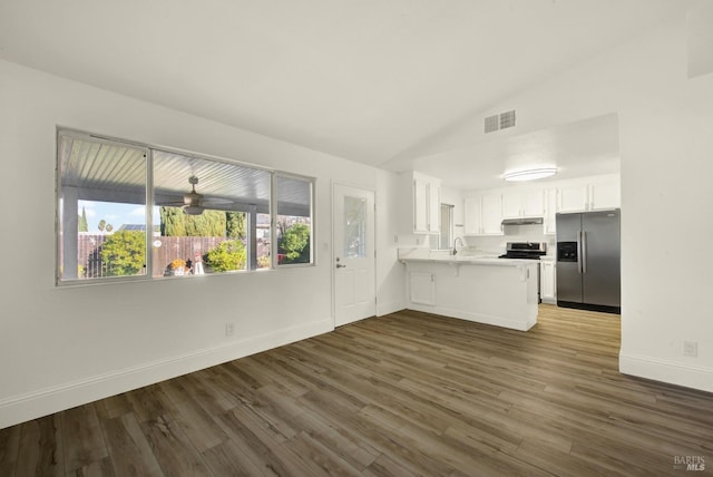 kitchen with lofted ceiling, dark hardwood / wood-style floors, white cabinets, stainless steel fridge with ice dispenser, and kitchen peninsula