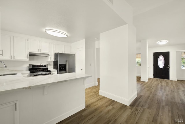 kitchen featuring a breakfast bar, sink, white cabinetry, kitchen peninsula, and stainless steel appliances