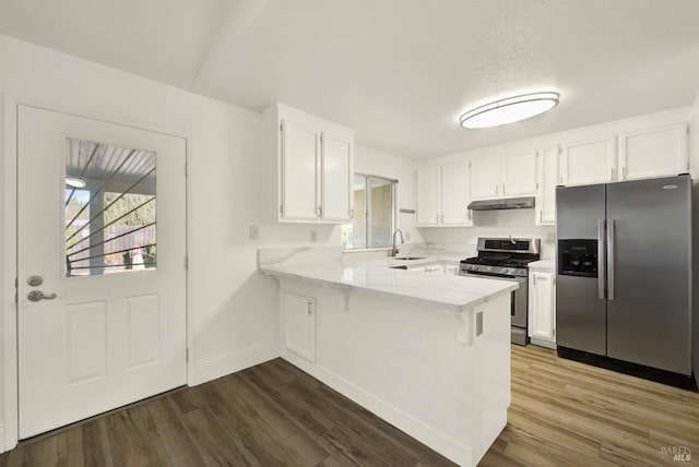 kitchen featuring sink, stainless steel appliances, dark hardwood / wood-style floors, white cabinets, and kitchen peninsula