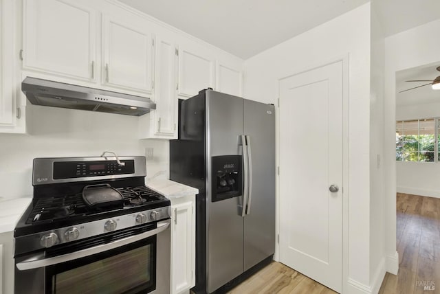 kitchen with stainless steel appliances, white cabinets, and light wood-type flooring