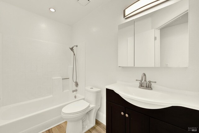 full bathroom featuring bathing tub / shower combination, hardwood / wood-style floors, vanity, and toilet