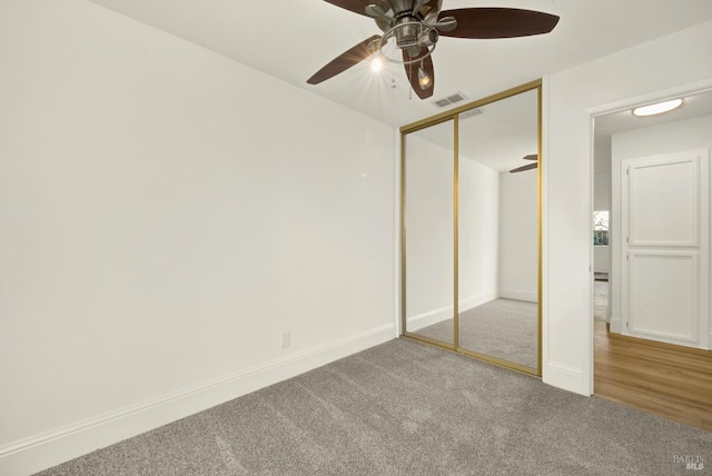 unfurnished bedroom with carpet flooring, ceiling fan, and a closet