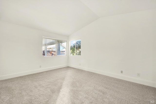 unfurnished room featuring lofted ceiling and carpet