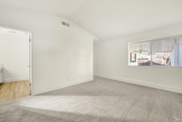 spare room with light carpet and lofted ceiling