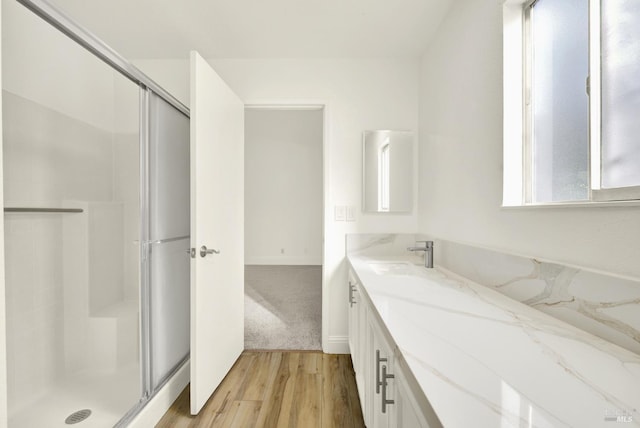 bathroom featuring hardwood / wood-style flooring, vanity, and an enclosed shower