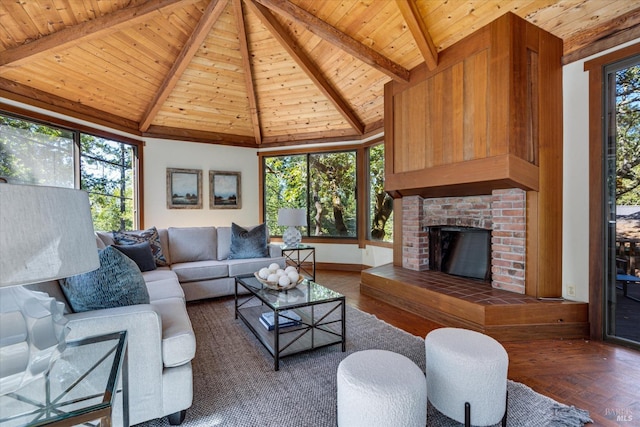 living room with a wealth of natural light, a fireplace, dark parquet floors, wooden ceiling, and beam ceiling