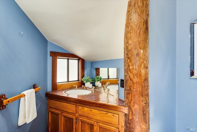 bathroom featuring vanity and lofted ceiling