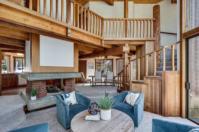 living room with light colored carpet, a chandelier, beam ceiling, and a towering ceiling