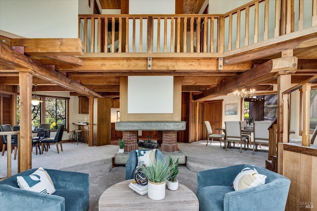 carpeted living room featuring a notable chandelier, a high ceiling, and a fireplace