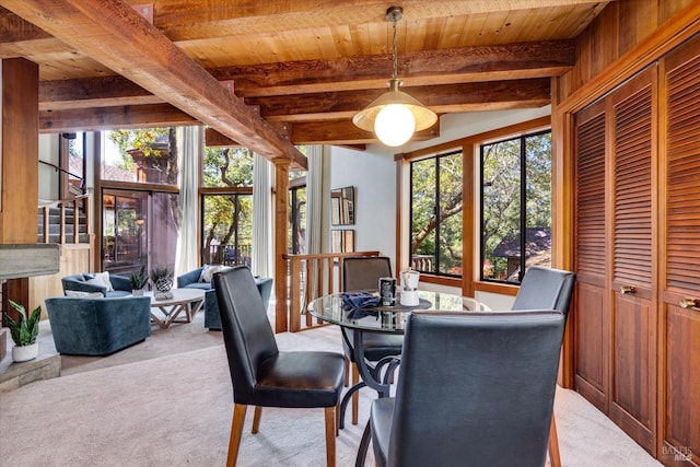 carpeted dining room featuring wood ceiling, beamed ceiling, and wood walls