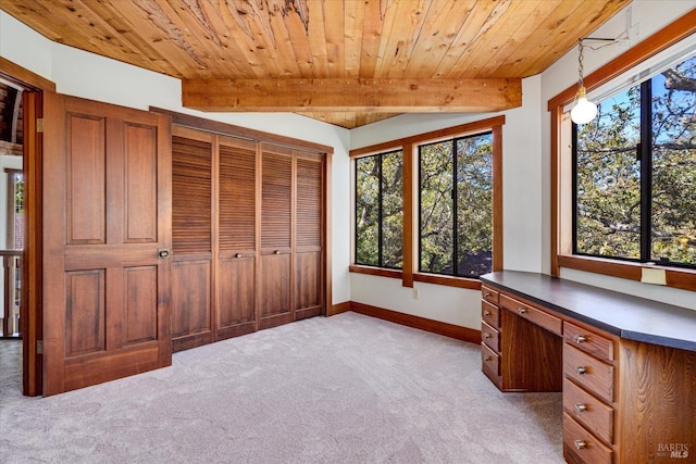 unfurnished office with beam ceiling, wooden ceiling, light carpet, and a healthy amount of sunlight