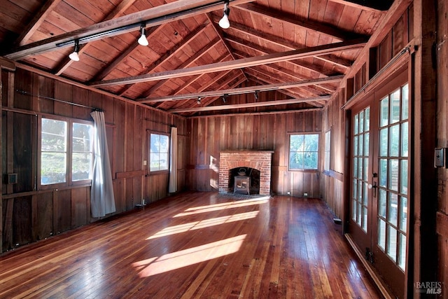 unfurnished living room featuring wood ceiling, dark hardwood / wood-style floors, and wood walls