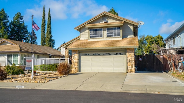 traditional-style home featuring driveway, an attached garage, a tile roof, and fence