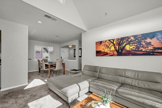 carpeted living room featuring a notable chandelier