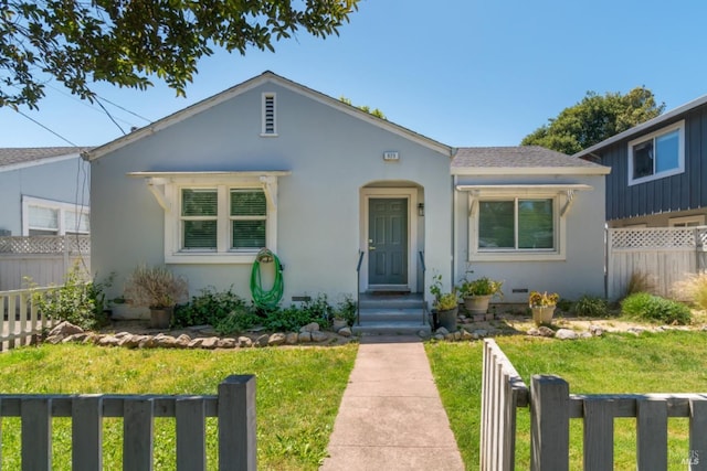 bungalow-style home with a front yard