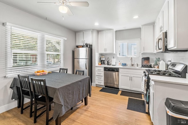 kitchen featuring sink, tasteful backsplash, stainless steel appliances, light hardwood / wood-style floors, and white cabinets