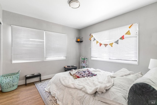 bedroom featuring multiple windows and hardwood / wood-style floors