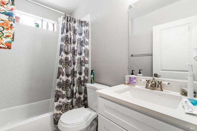 full bathroom with vanity, shower / tub combo, and toilet