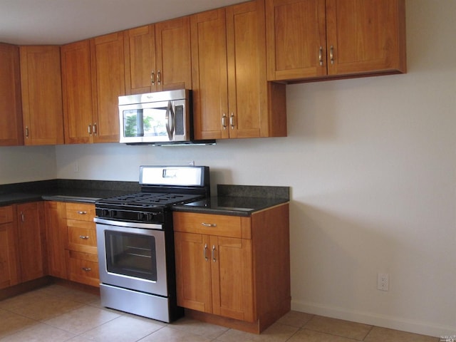 kitchen with stainless steel appliances and light tile patterned flooring