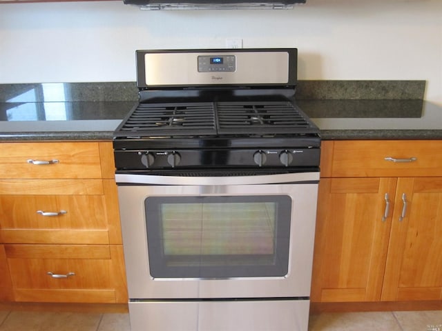 kitchen with light tile patterned floors and stainless steel range with gas stovetop