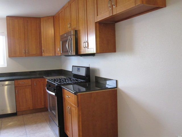 kitchen with light tile patterned floors and stainless steel appliances