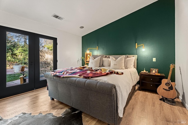 bedroom with french doors, access to exterior, and light wood-type flooring