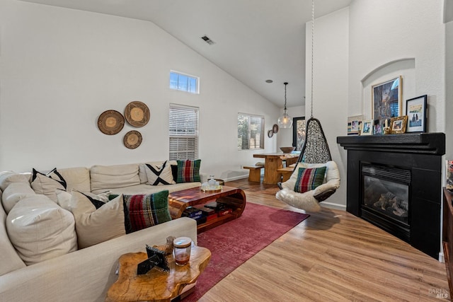 living room with wood-type flooring and high vaulted ceiling