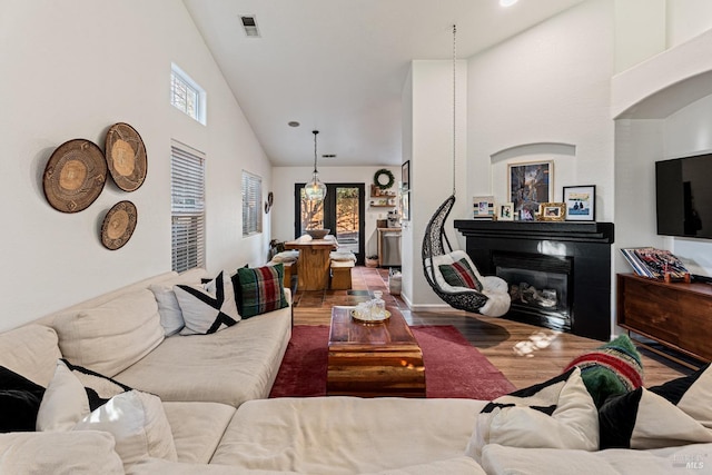 living room with hardwood / wood-style floors and high vaulted ceiling