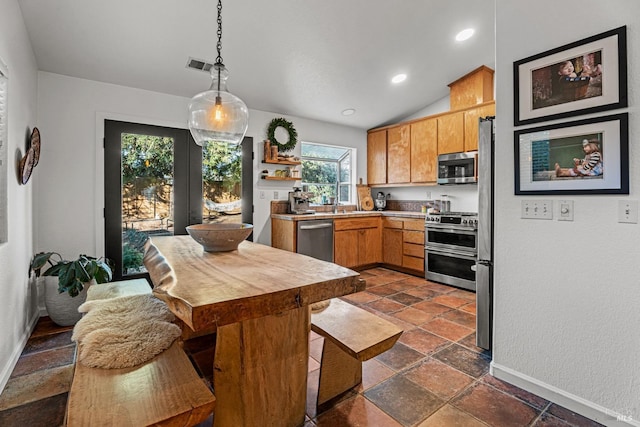 kitchen featuring hanging light fixtures, plenty of natural light, stainless steel appliances, and sink