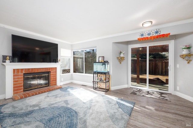 living room with a brick fireplace, crown molding, and hardwood / wood-style floors