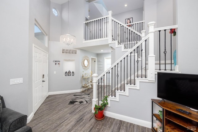 foyer entrance with a wealth of natural light, a chandelier, hardwood / wood-style floors, and a high ceiling