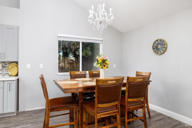 dining room featuring lofted ceiling, dark hardwood / wood-style floors, and a chandelier