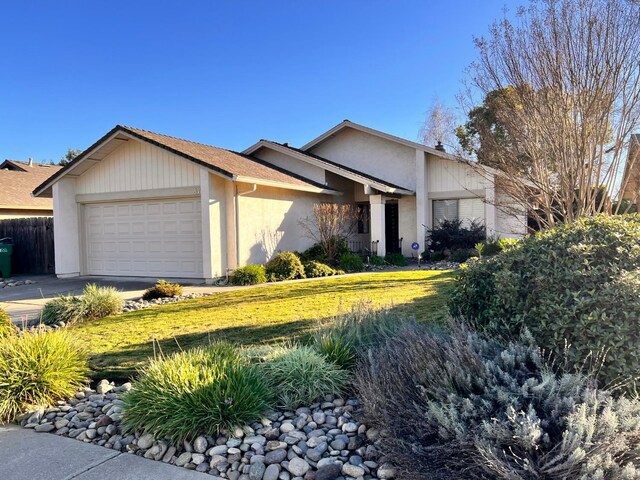 ranch-style house featuring a garage and a front lawn