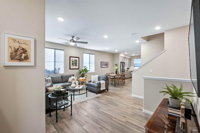 living area with baseboards, a ceiling fan, light wood-style flooring, and recessed lighting