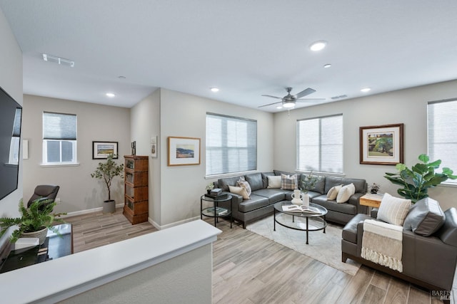 living room with ceiling fan and light hardwood / wood-style flooring