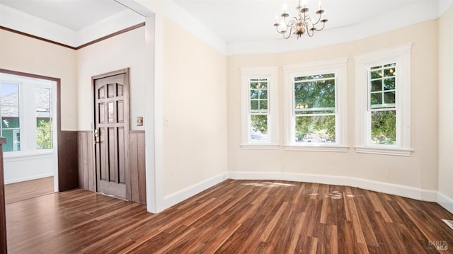 foyer entrance featuring a healthy amount of sunlight, dark hardwood / wood-style floors, and a notable chandelier