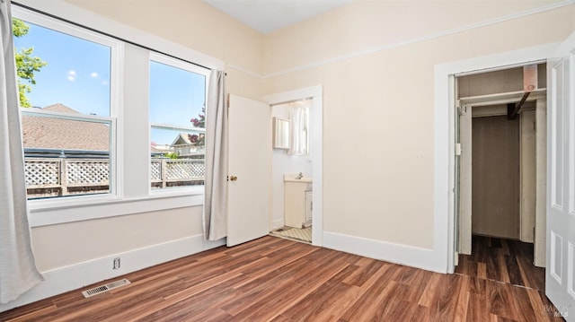 unfurnished bedroom featuring dark hardwood / wood-style flooring and a closet