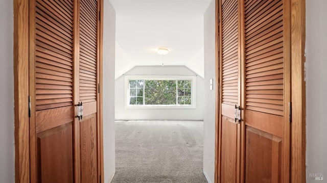 hallway with vaulted ceiling and carpet