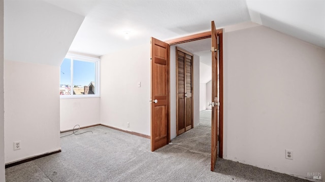 additional living space with lofted ceiling and light carpet