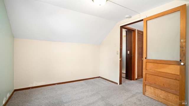 additional living space with vaulted ceiling and light carpet