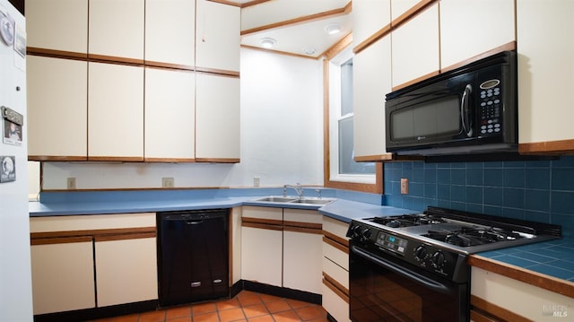 kitchen with light tile patterned flooring, sink, black appliances, white cabinets, and backsplash