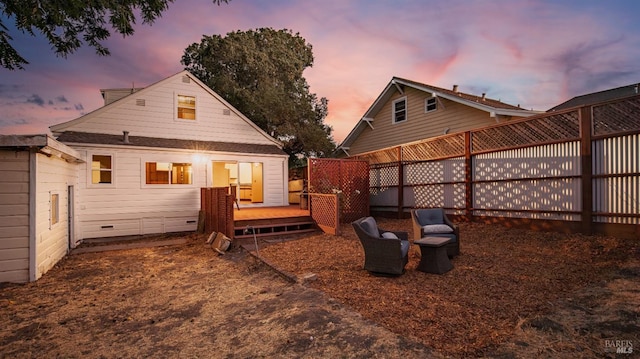 back house at dusk with a wooden deck