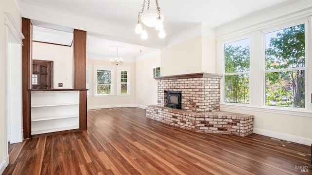 unfurnished living room featuring ornamental molding, dark hardwood / wood-style floors, and a notable chandelier