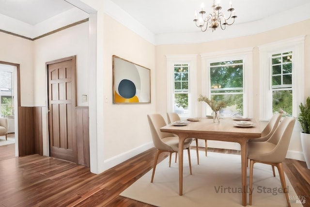 dining space with dark hardwood / wood-style flooring and a chandelier